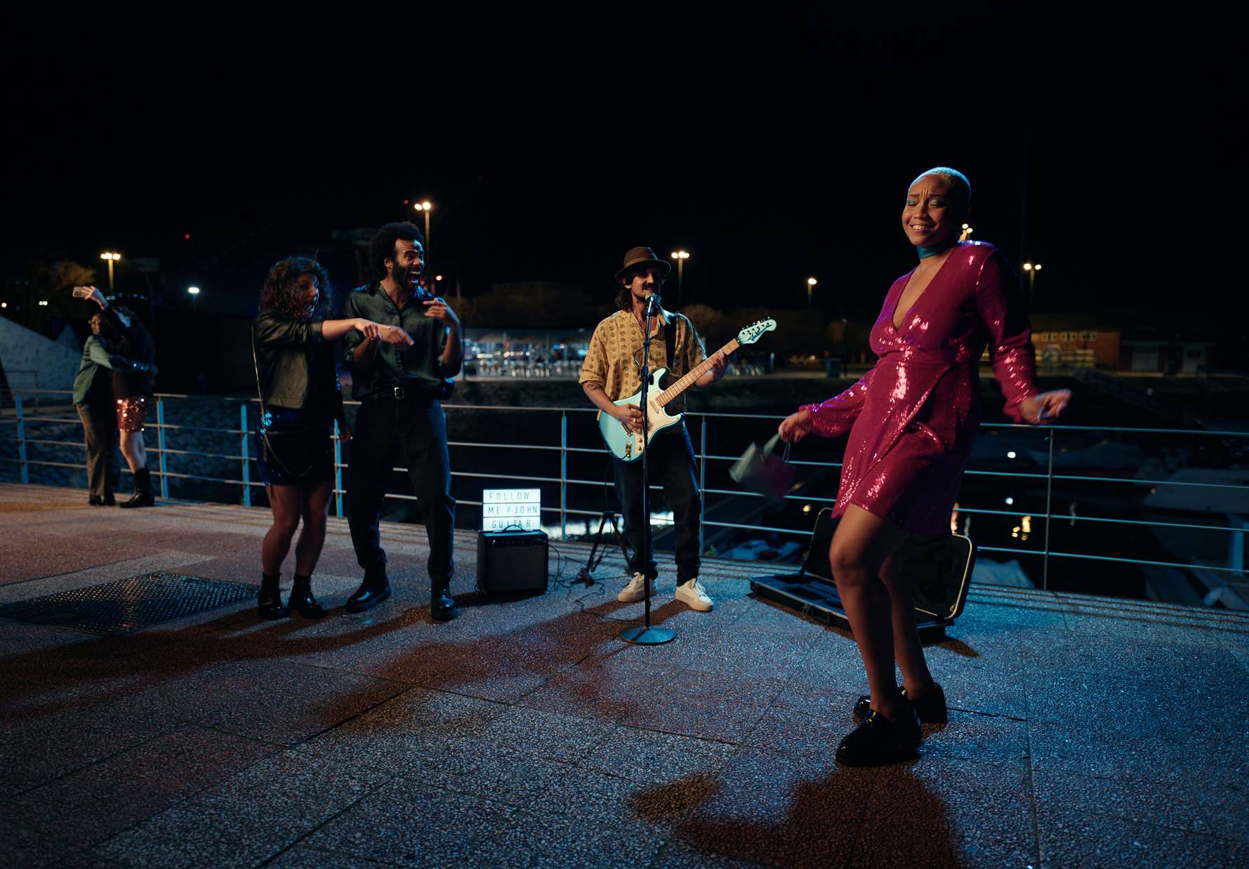 Woman in sparkly dress dancing next to band